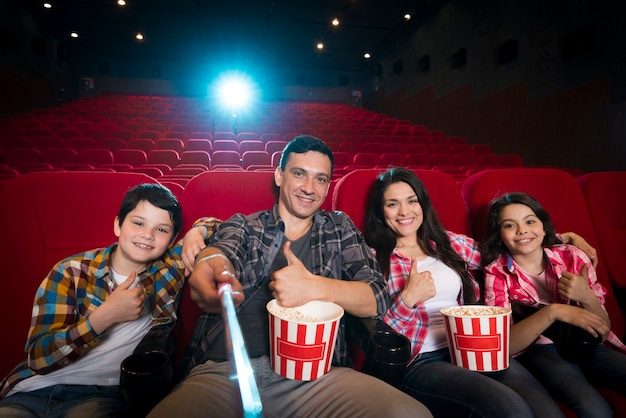 Familia feliz sentada en cine