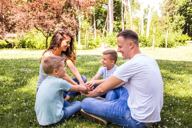 Foto gratuita familia feliz sentada en el parque