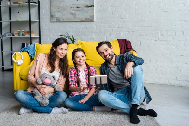 Familia feliz sentada en el piso