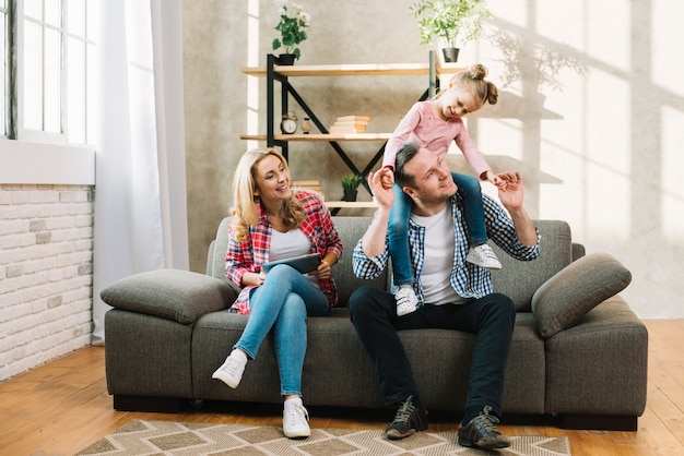 Familia feliz sentado en el sofá en la sala de estar