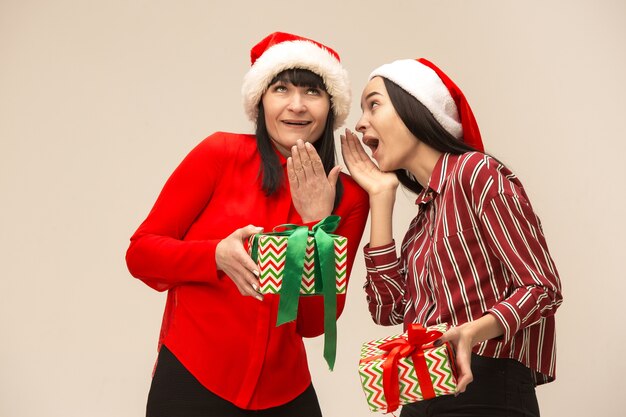 Familia feliz en suéter de Navidad posando con regalos