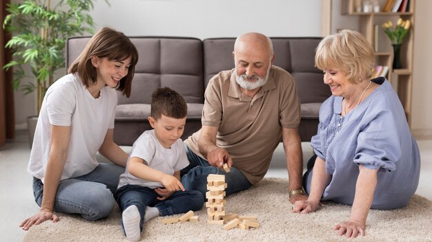 Familia feliz de tiro completo jugando en el piso