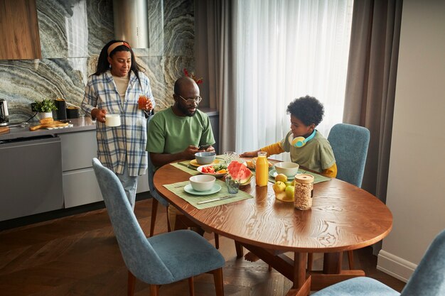 Familia feliz de tiro completo en la mesa