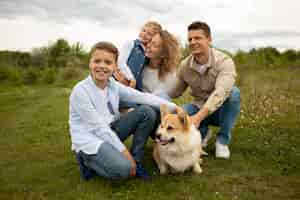 Foto gratuita familia feliz de tiro completo con perro adorable