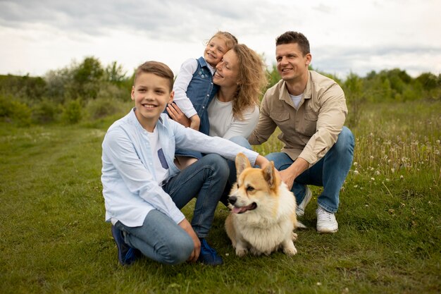 Familia feliz de tiro completo con perro adorable