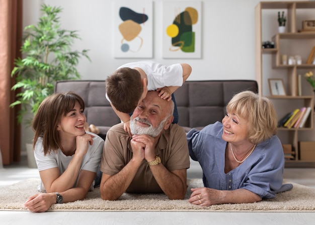 Familia feliz de tiro completo en el piso en el interior