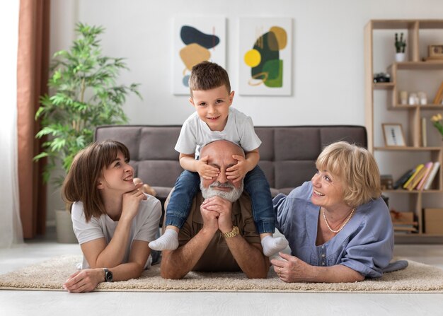 Familia feliz de tiro completo en el piso