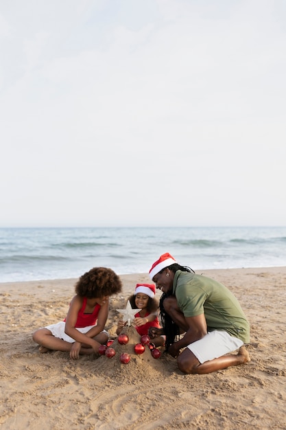 Foto gratuita familia feliz de tiro completo en la playa