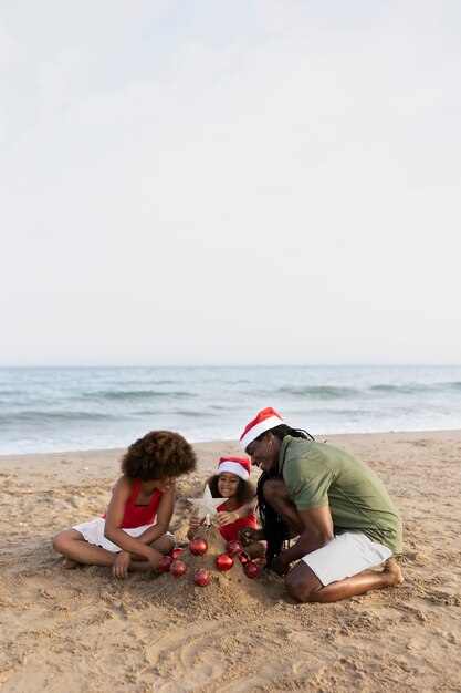 Familia feliz de tiro completo en la playa