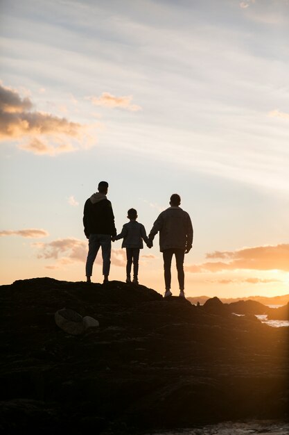 Familia feliz de tiro largo al atardecer