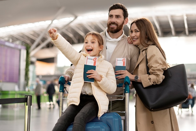 Foto gratuita familia feliz de tiro medio en el aeropuerto