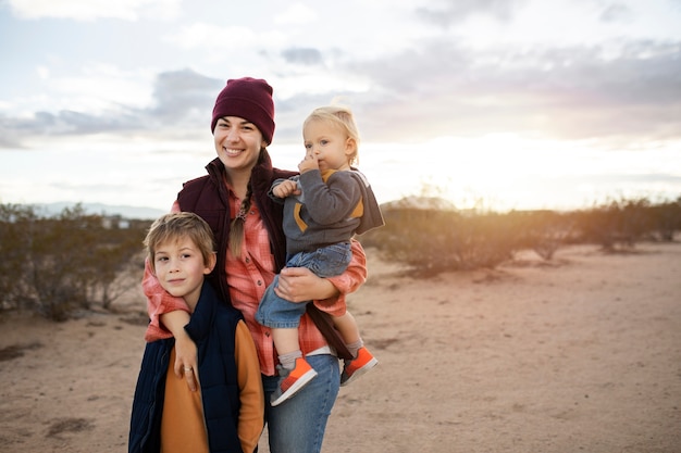 Foto gratuita familia feliz de tiro medio en el desierto americano