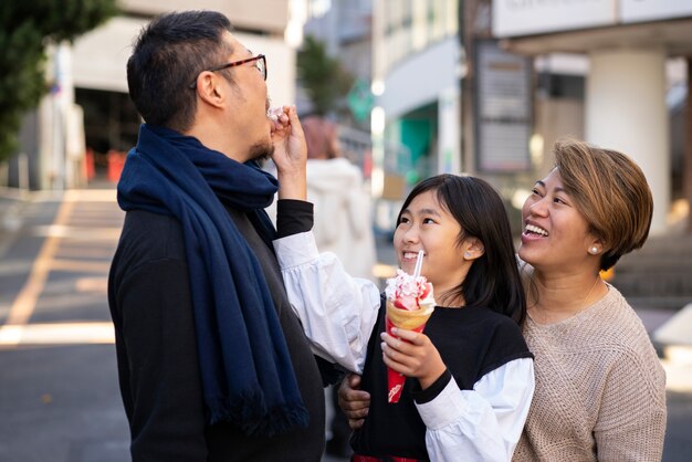 Familia feliz de tiro medio con helado