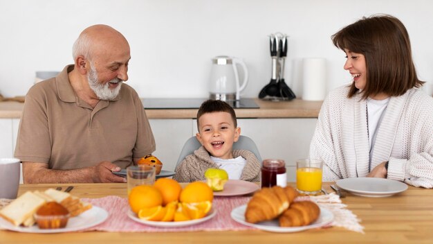 Familia feliz de tiro medio en la mesa