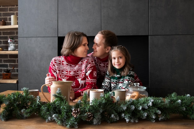 Familia feliz de tiro medio durante la Navidad