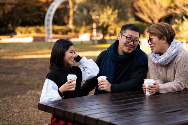 Familia feliz de tiro medio en el parque