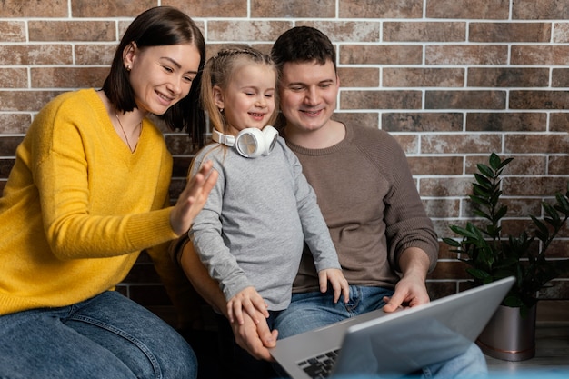 Familia feliz de tiro medio con portátil