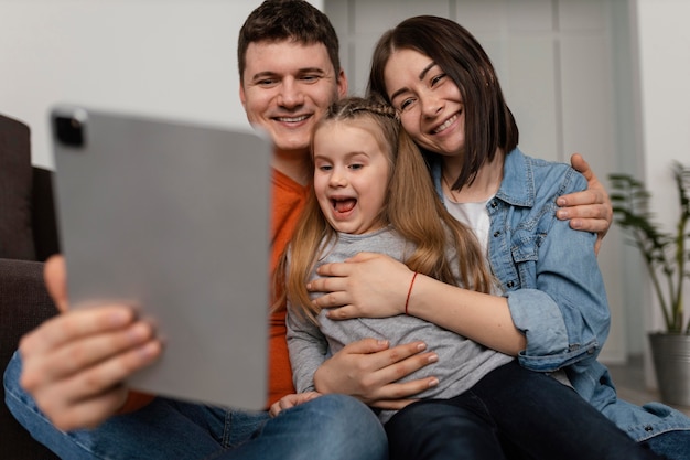 Familia feliz de tiro medio con portátil