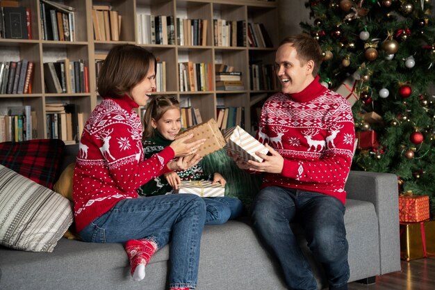 Familia feliz de tiro medio con regalos