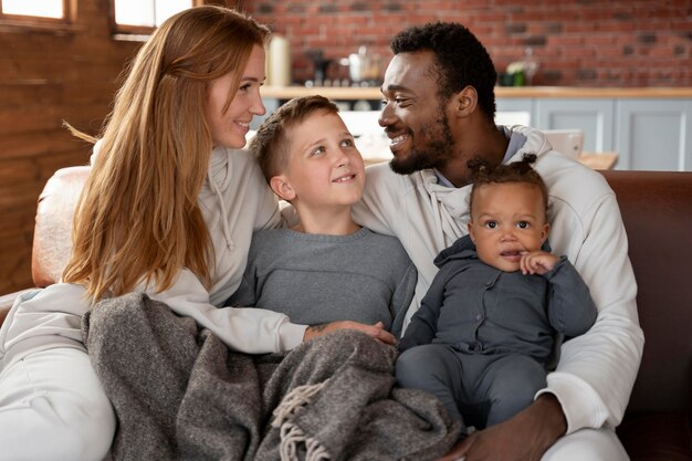 Familia feliz de tiro medio sentado en el sofá