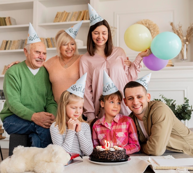 Familia feliz de tiro medio con sombreros de fiesta