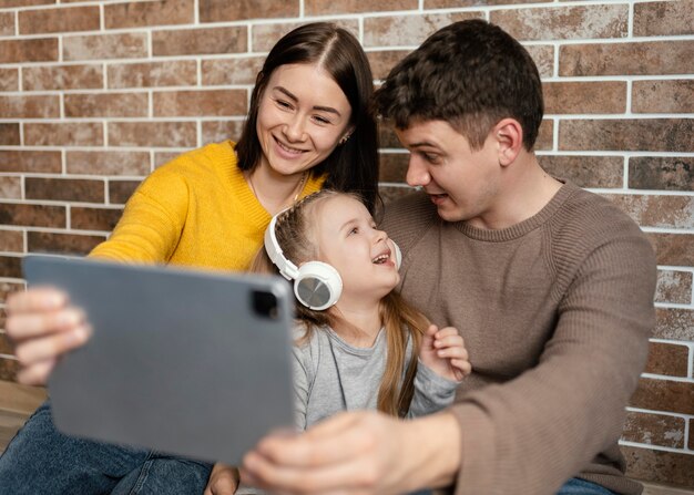 Familia feliz de tiro medio con tableta