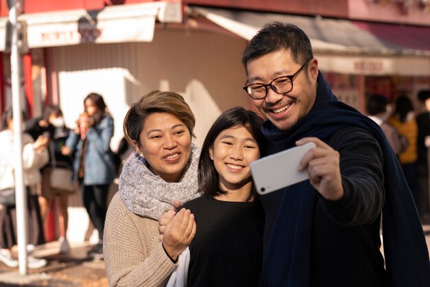 Familia feliz de tiro medio tomando selfie