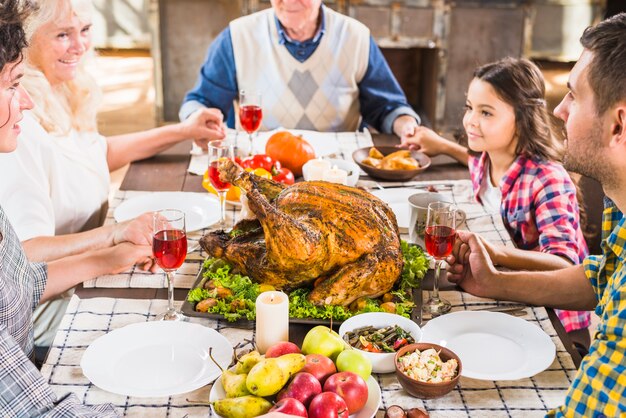 Familia feliz tomados de la mano en la mesa