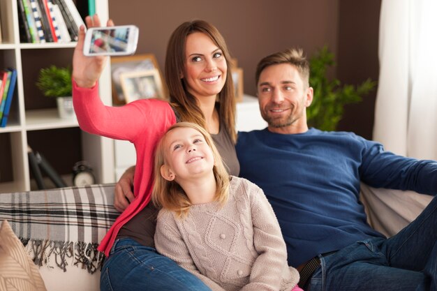 Familia feliz tomando selfie en casa