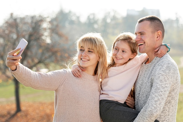 Familia feliz tomando una selfie en la naturaleza