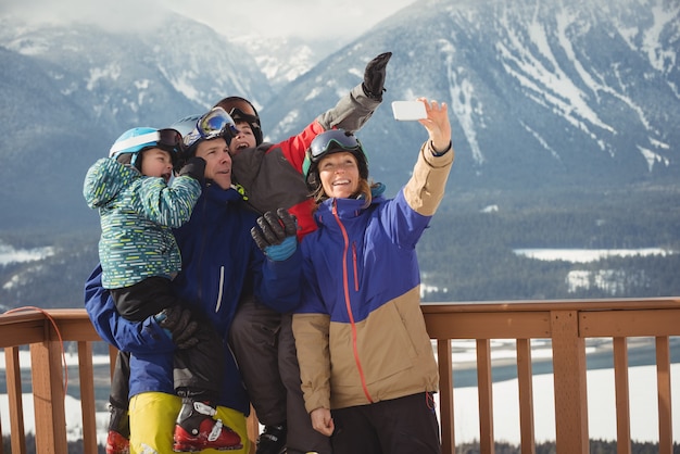 Familia feliz tomando selfie en teléfono móvil