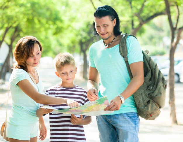 Familia feliz de tres buscando forma en el mapa