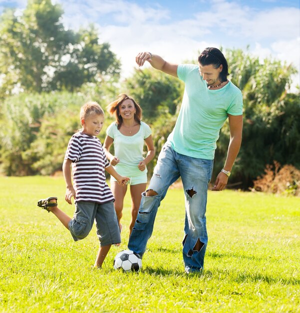 Familia feliz de tres jugando con la pelota