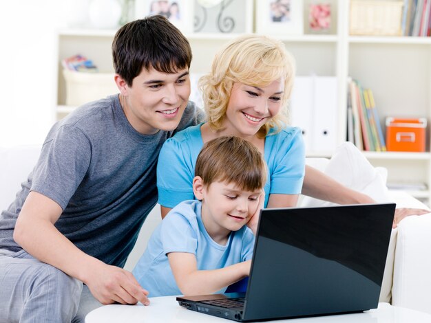 Familia feliz usando laptop en casa