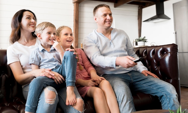 Foto gratuita familia feliz viendo televisión