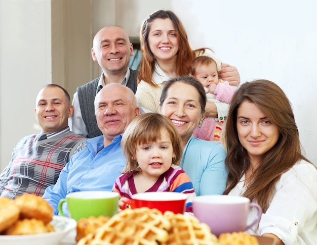 Familia grande feliz tomando el té