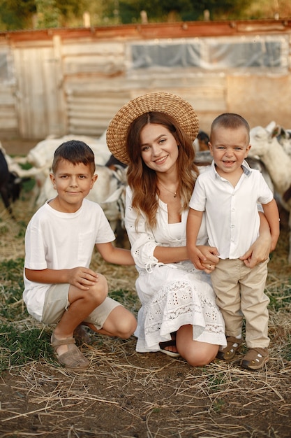 Familia en una granja. Gente jugando con cabras. Madre con hijo.