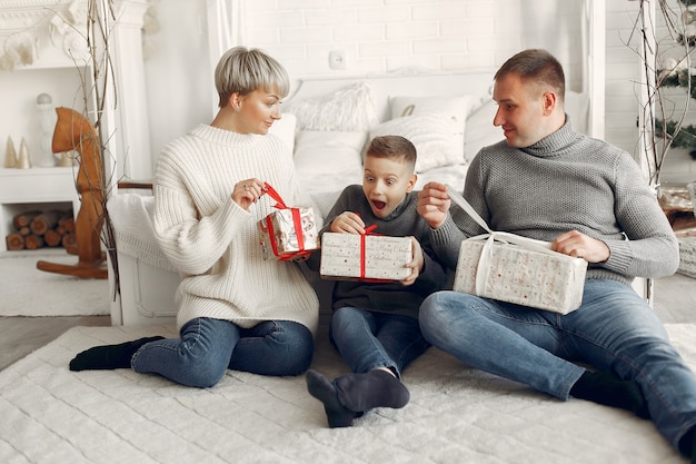 Familia en una habitación. Niño cerca de la decoración navideña. Madre con padre con hijo