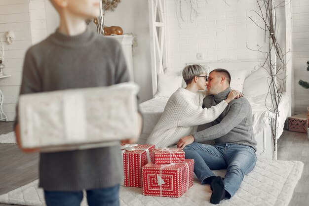 Familia en una habitación. Niño cerca de la decoración navideña. Madre con padre con hijo