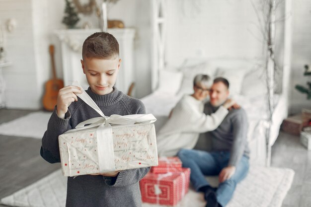 Foto gratuita familia en una habitación. niño cerca de la decoración navideña. madre con padre con hijo