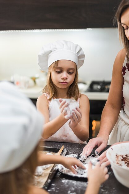 Familia haciendo galletas con harina en la cocina