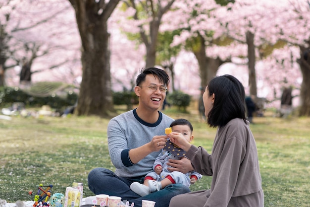 Familia haciendo un picnic junto a un cerezo