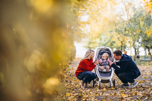 Familia con hija bebé caminando en un parque de otoño