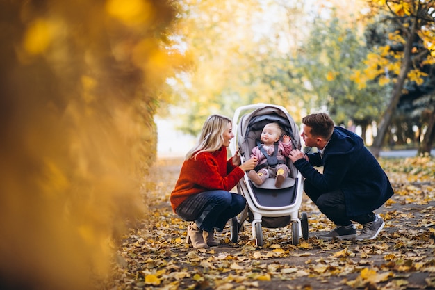 Foto gratuita familia con hija bebé caminando en un parque de otoño