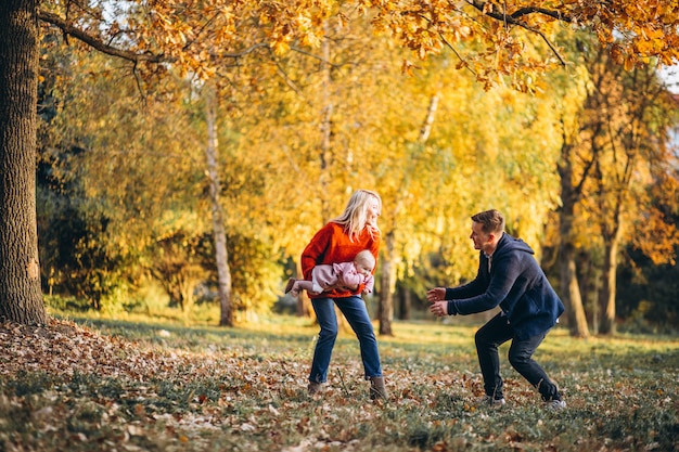 Familia con hija caminando en un parque de otoño