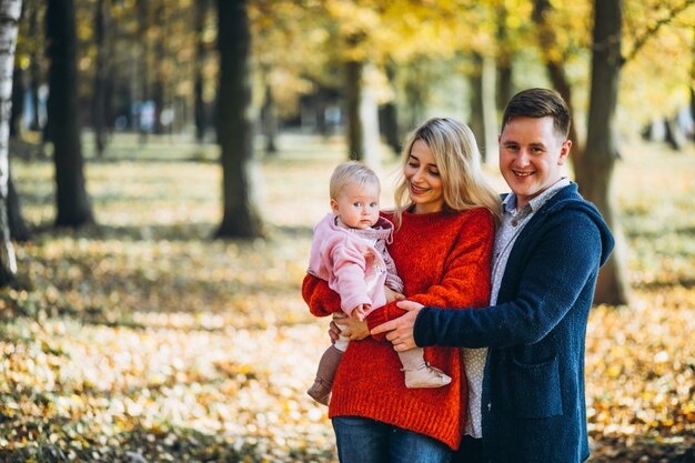 Familia con hija en un parque de otoño