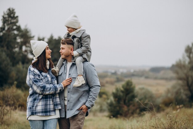 Familia con hija pequeña juntos en clima otoñal divirtiéndose