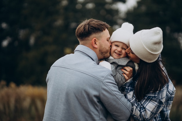 Familia con hija pequeña juntos en clima otoñal divirtiéndose