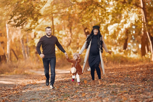 Familia con hija pequeña en un parque de otoño