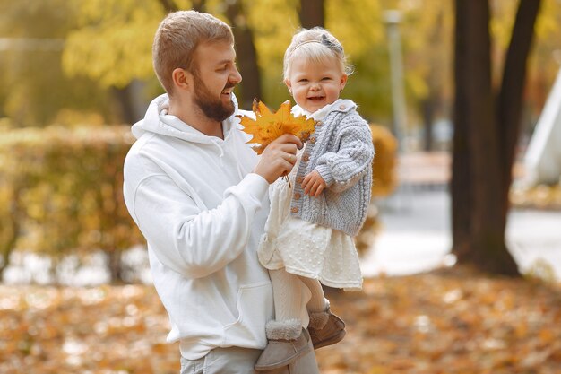 Familia con hija pequeña en un parque de otoño